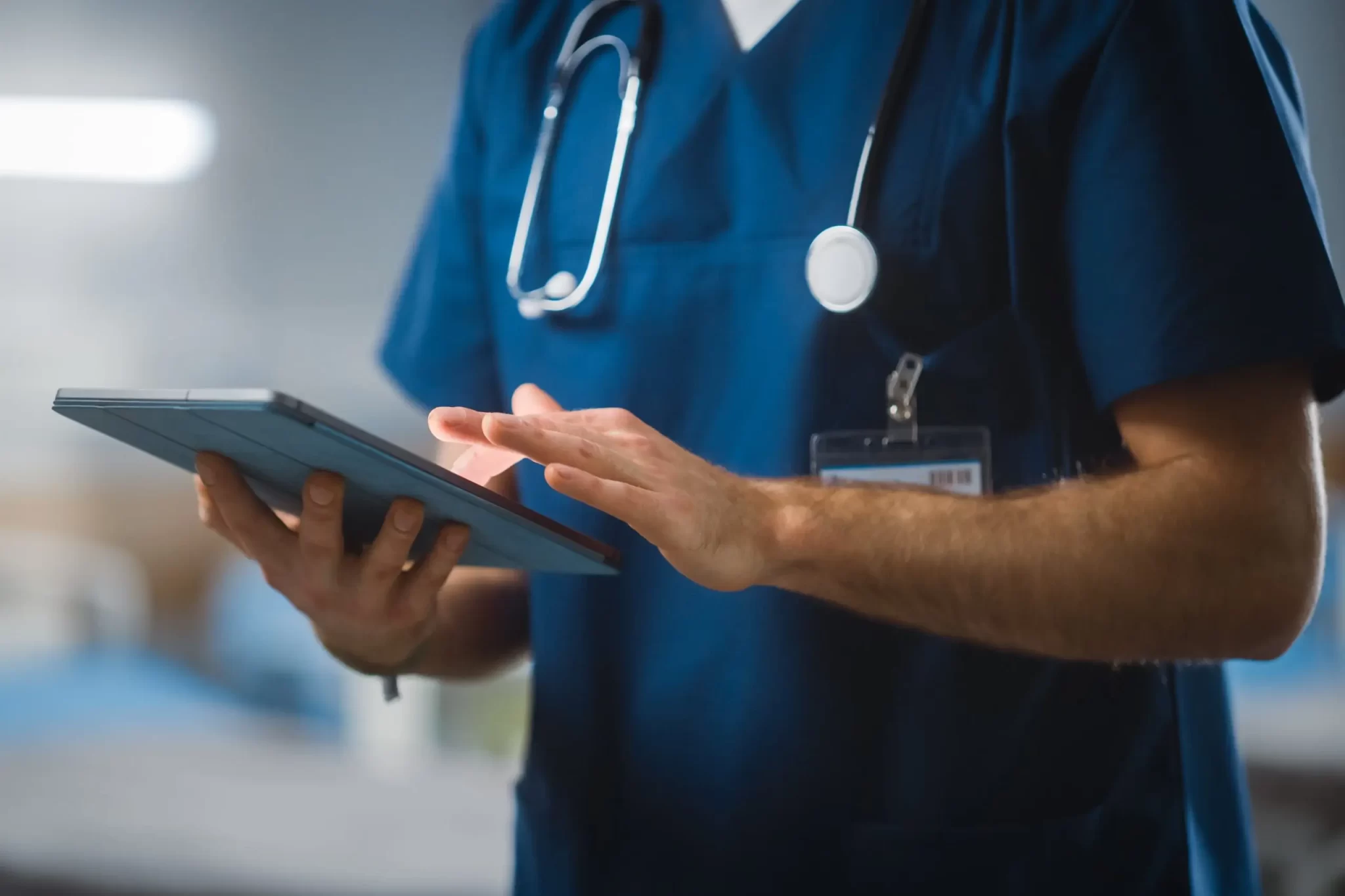 Nurse, Doctor, Surgeon Uses Digital Tablet Computer Health Care Vitals Monitoring Computer Machine. Modern Clinic with Advanced Equipment and Professional Working